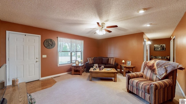 living room featuring a textured ceiling, ceiling fan, and carpet