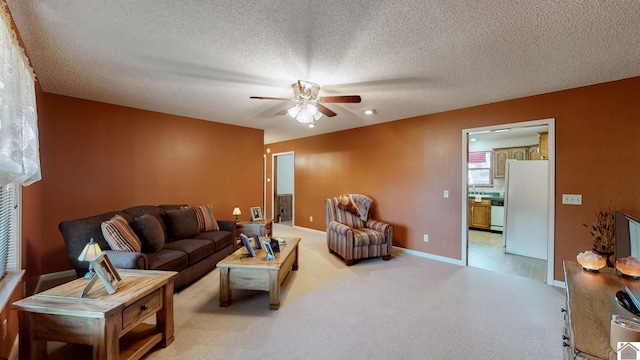 carpeted living room with ceiling fan and a textured ceiling