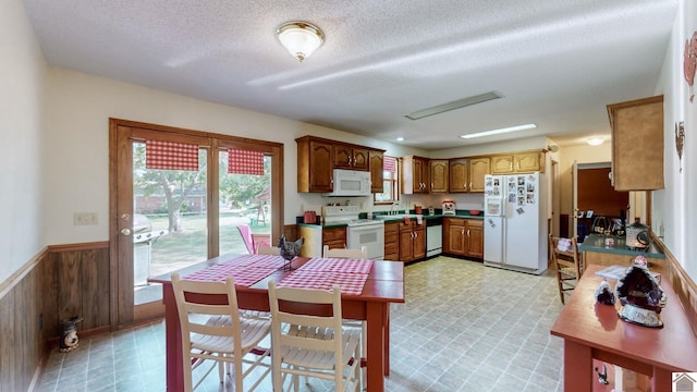 dining room with a textured ceiling, wood walls, and sink