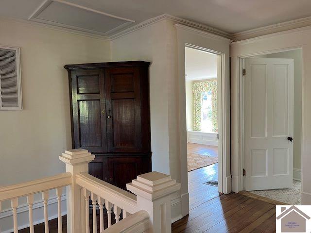 hallway featuring wood-type flooring and crown molding