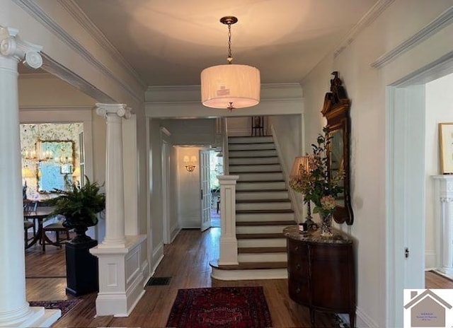 foyer with ornamental molding, dark wood-type flooring, and decorative columns