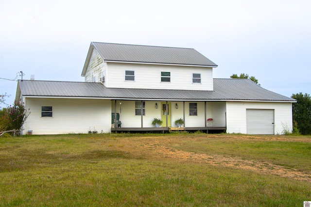 view of front of house with a garage, a front yard, and covered porch