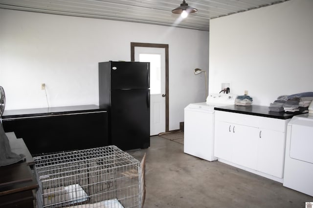 clothes washing area featuring separate washer and dryer and cabinets