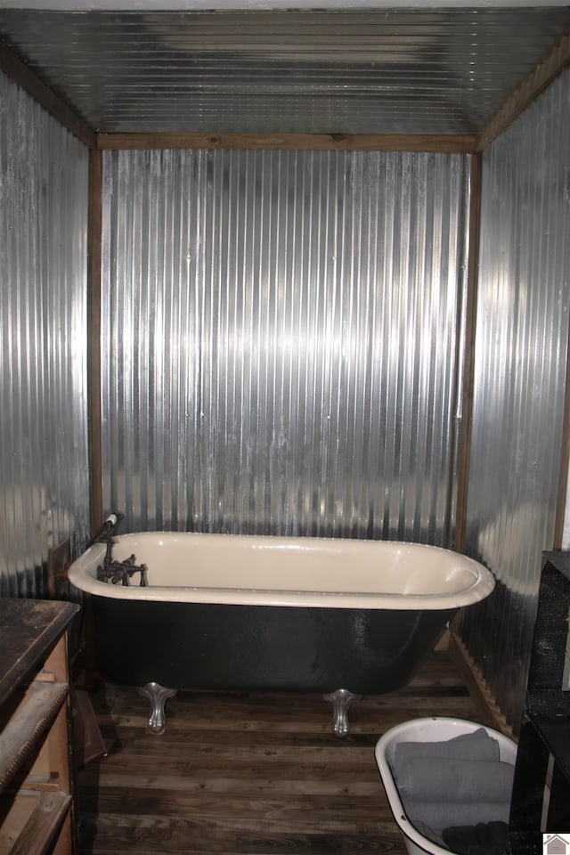 bathroom with wood-type flooring, vanity, and a tub