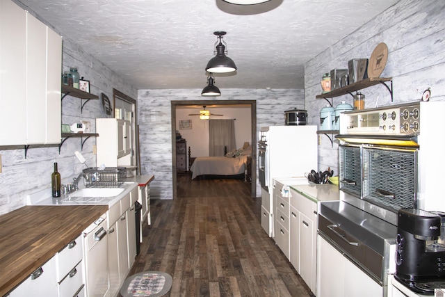 kitchen featuring white cabinetry, wood counters, hanging light fixtures, and dark hardwood / wood-style flooring