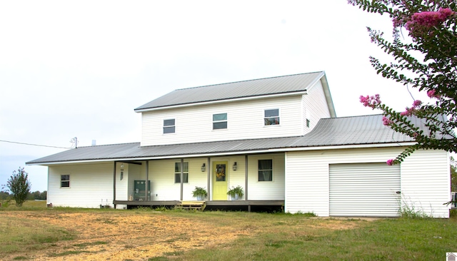 view of front of property featuring a front lawn, a porch, and a garage