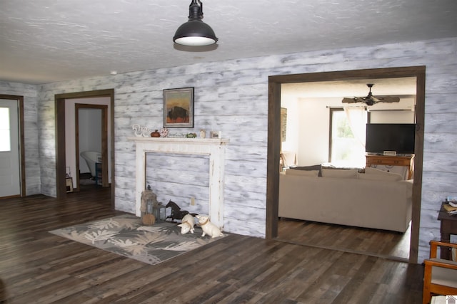 living room with a textured ceiling and dark wood-type flooring