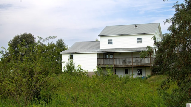 rear view of house featuring a wooden deck