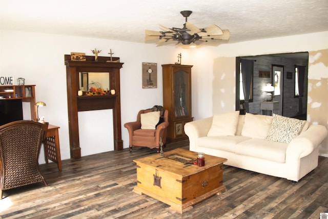 living room with ceiling fan, dark hardwood / wood-style floors, and a textured ceiling