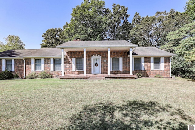 ranch-style house featuring covered porch and a front lawn