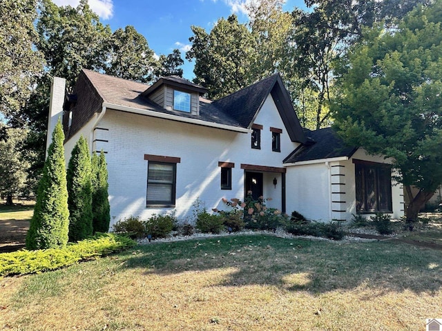 view of front of home with brick siding and a front yard