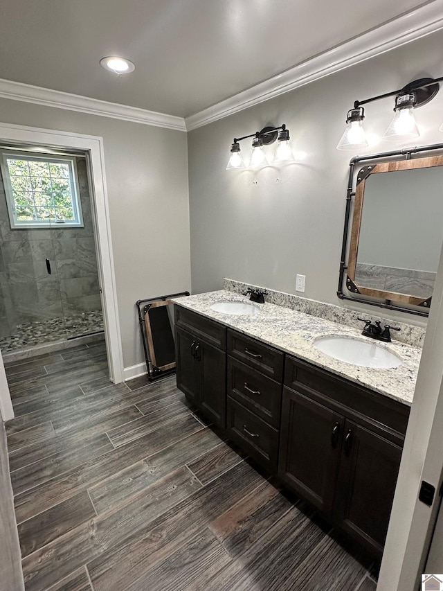 bathroom with a stall shower, ornamental molding, a sink, and wood finished floors