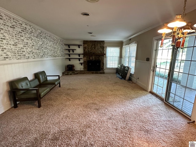 living area with visible vents, wainscoting, carpet, crown molding, and a fireplace