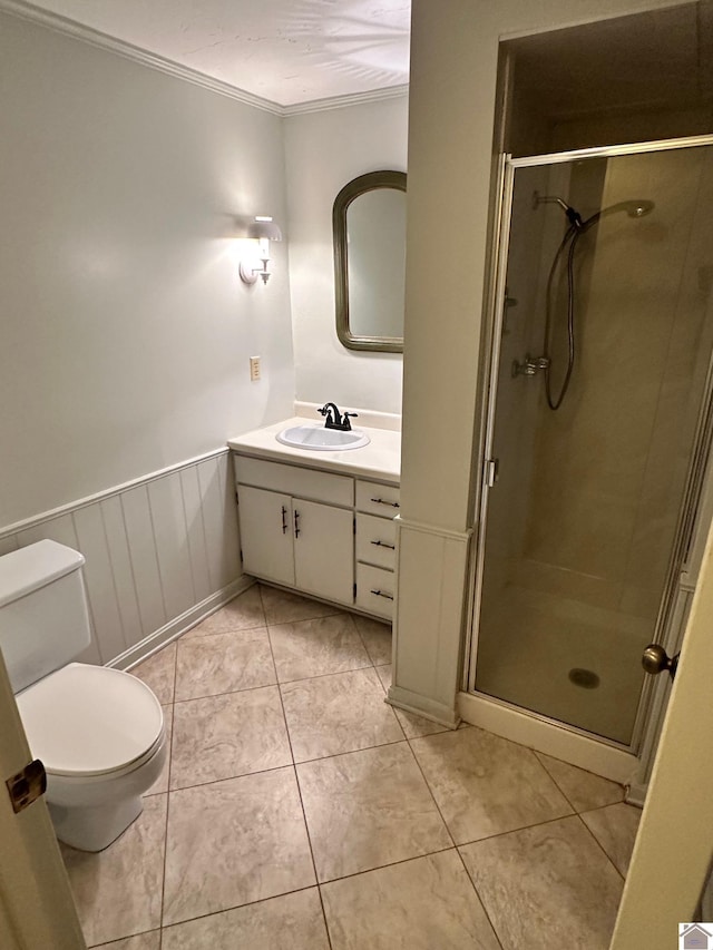 bathroom with crown molding, toilet, a stall shower, vanity, and tile patterned flooring