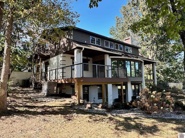 back of property featuring brick siding and a chimney