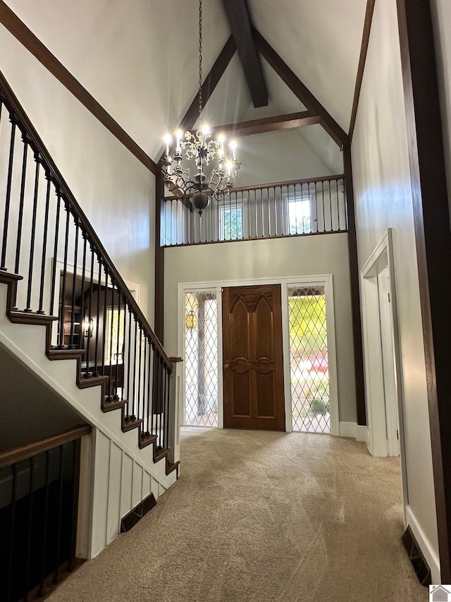 foyer featuring high vaulted ceiling, a notable chandelier, visible vents, stairs, and carpet