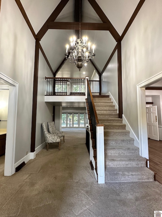 stairs featuring baseboards, high vaulted ceiling, a notable chandelier, and carpet flooring