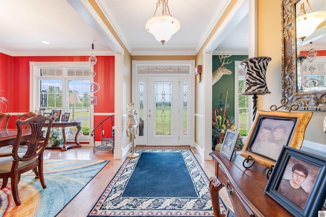 entrance foyer featuring wood-type flooring and crown molding