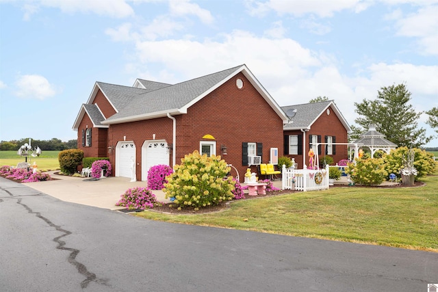 view of front of property featuring cooling unit, a garage, and a front yard