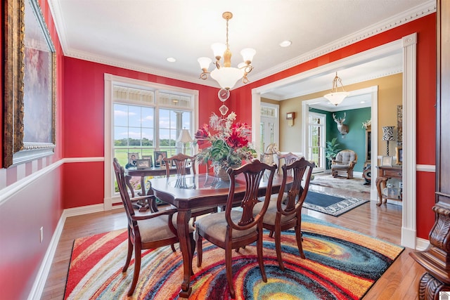 dining area featuring crown molding, a notable chandelier, and wood-type flooring