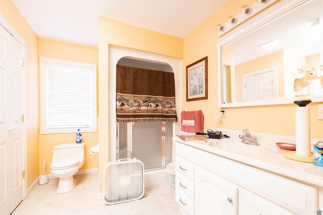 bathroom featuring tile patterned flooring, toilet, and vanity