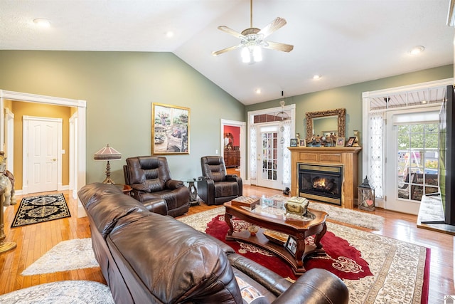 living room with light hardwood / wood-style flooring, vaulted ceiling, and ceiling fan