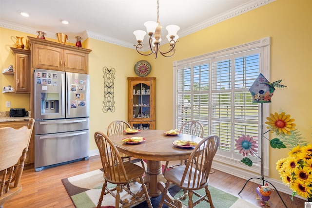 dining area featuring light wood-type flooring, crown molding, and a chandelier