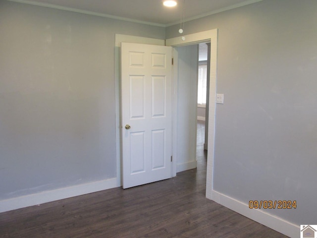 unfurnished bedroom featuring dark wood-type flooring and crown molding