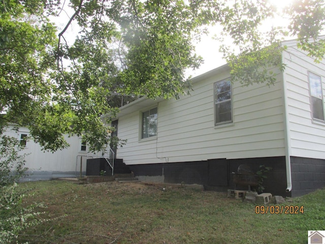 view of property exterior with a lawn