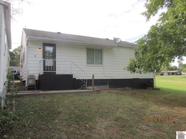 back of house featuring a lawn