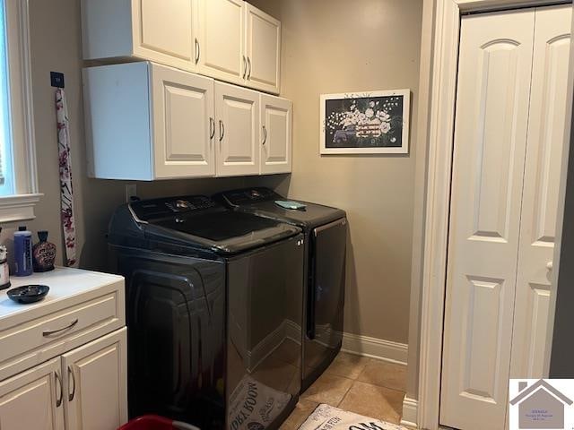 laundry area with washing machine and dryer, cabinets, and light tile patterned floors