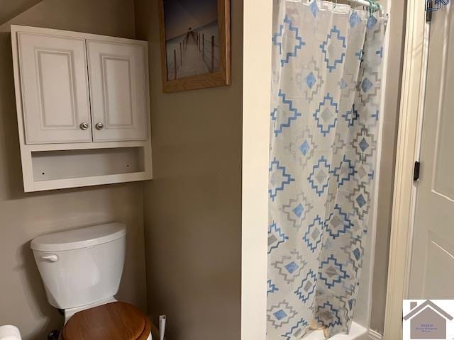 bathroom featuring curtained shower and toilet