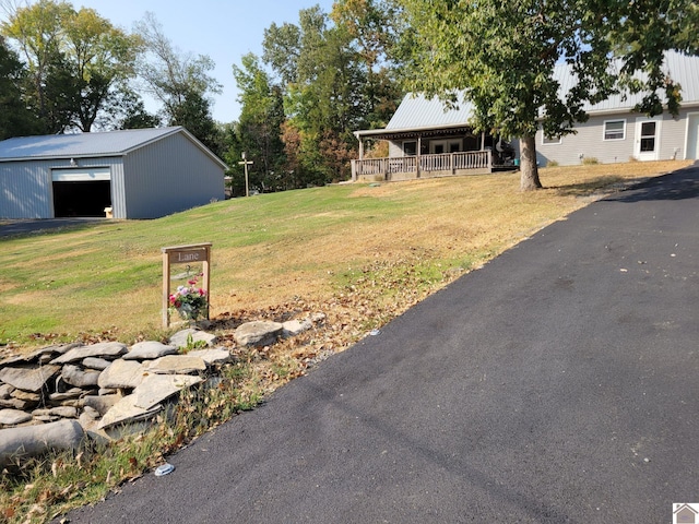 view of yard featuring an outbuilding, a garage, and a porch