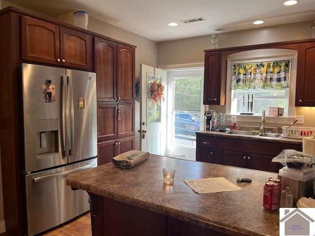 kitchen with stainless steel fridge with ice dispenser, light wood-type flooring, and sink