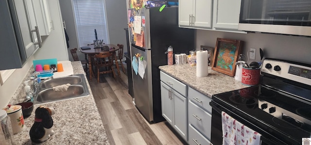 kitchen featuring light hardwood / wood-style flooring, white cabinets, appliances with stainless steel finishes, and sink