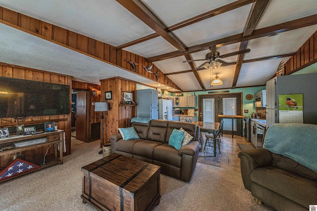 carpeted living room with lofted ceiling with beams, french doors, ceiling fan, and wooden walls