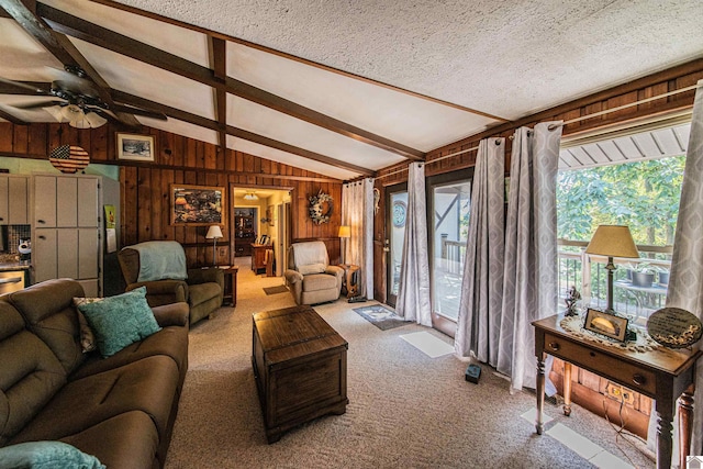 living room featuring lofted ceiling with beams, a textured ceiling, ceiling fan, and carpet