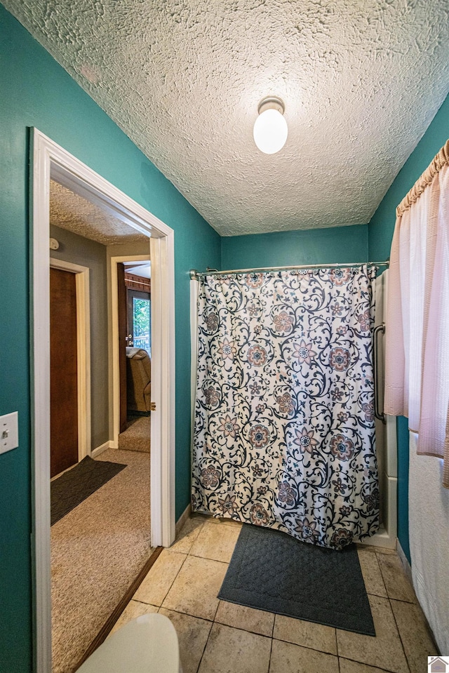 bathroom with tile patterned flooring and a textured ceiling