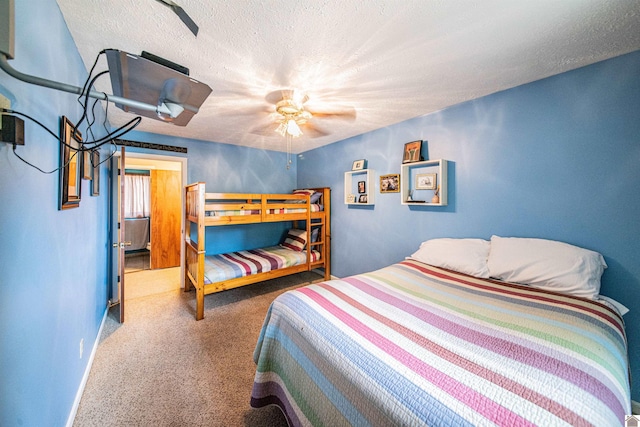 carpeted bedroom with ceiling fan and a textured ceiling