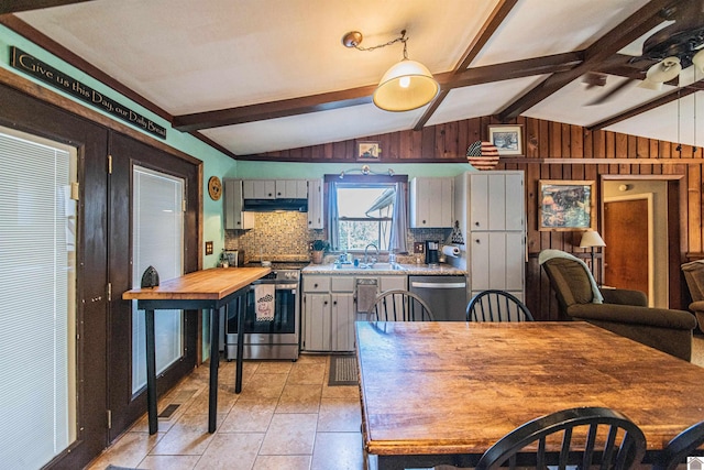 kitchen featuring gray cabinets, stainless steel appliances, ceiling fan, decorative backsplash, and lofted ceiling with beams