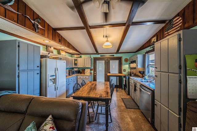 kitchen with appliances with stainless steel finishes, beam ceiling, french doors, sink, and ceiling fan