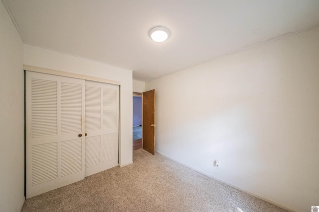 unfurnished bedroom featuring carpet floors and a closet