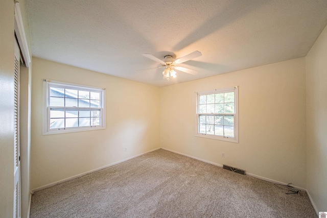 carpeted empty room with a textured ceiling and ceiling fan