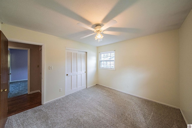 unfurnished bedroom featuring a textured ceiling, carpet flooring, ceiling fan, and a closet