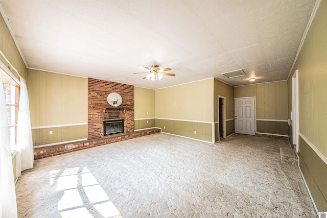 unfurnished living room featuring a fireplace, light carpet, a textured ceiling, and ceiling fan