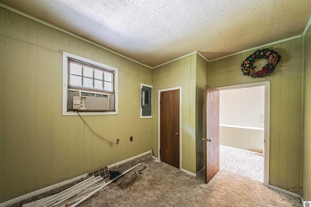 interior space with a textured ceiling, cooling unit, electric panel, light colored carpet, and wooden walls