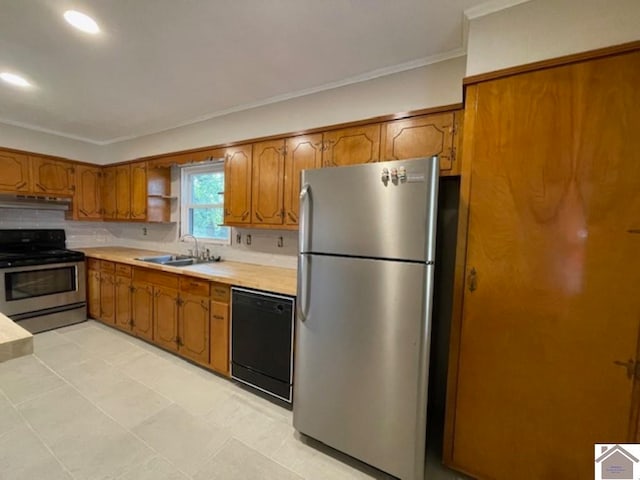 kitchen featuring ornamental molding, backsplash, light tile patterned floors, stainless steel appliances, and sink