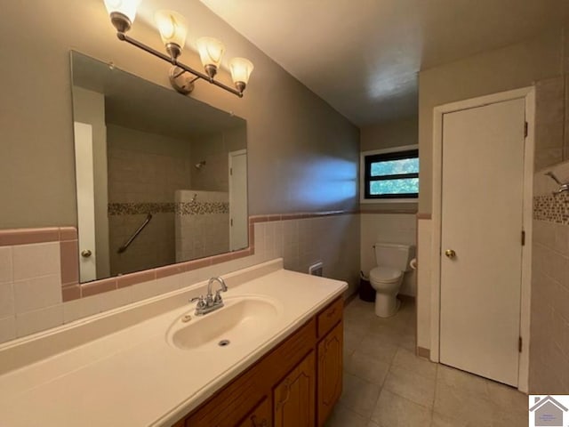 bathroom with vanity, toilet, tile walls, and decorative backsplash