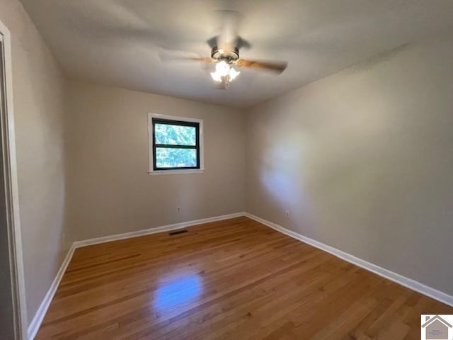 empty room with hardwood / wood-style flooring and ceiling fan