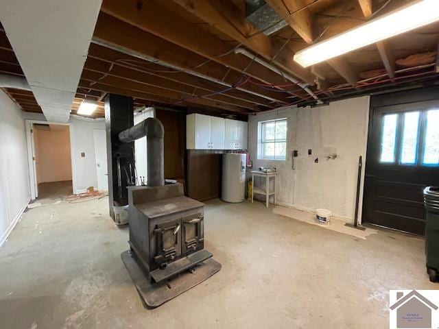 basement featuring a wood stove and water heater